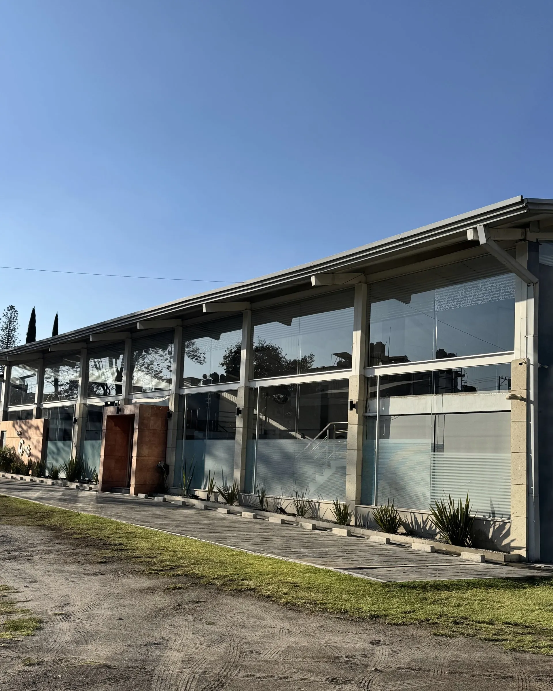 La fachada de cristal de Eventos Gons bajo el cielo azul
