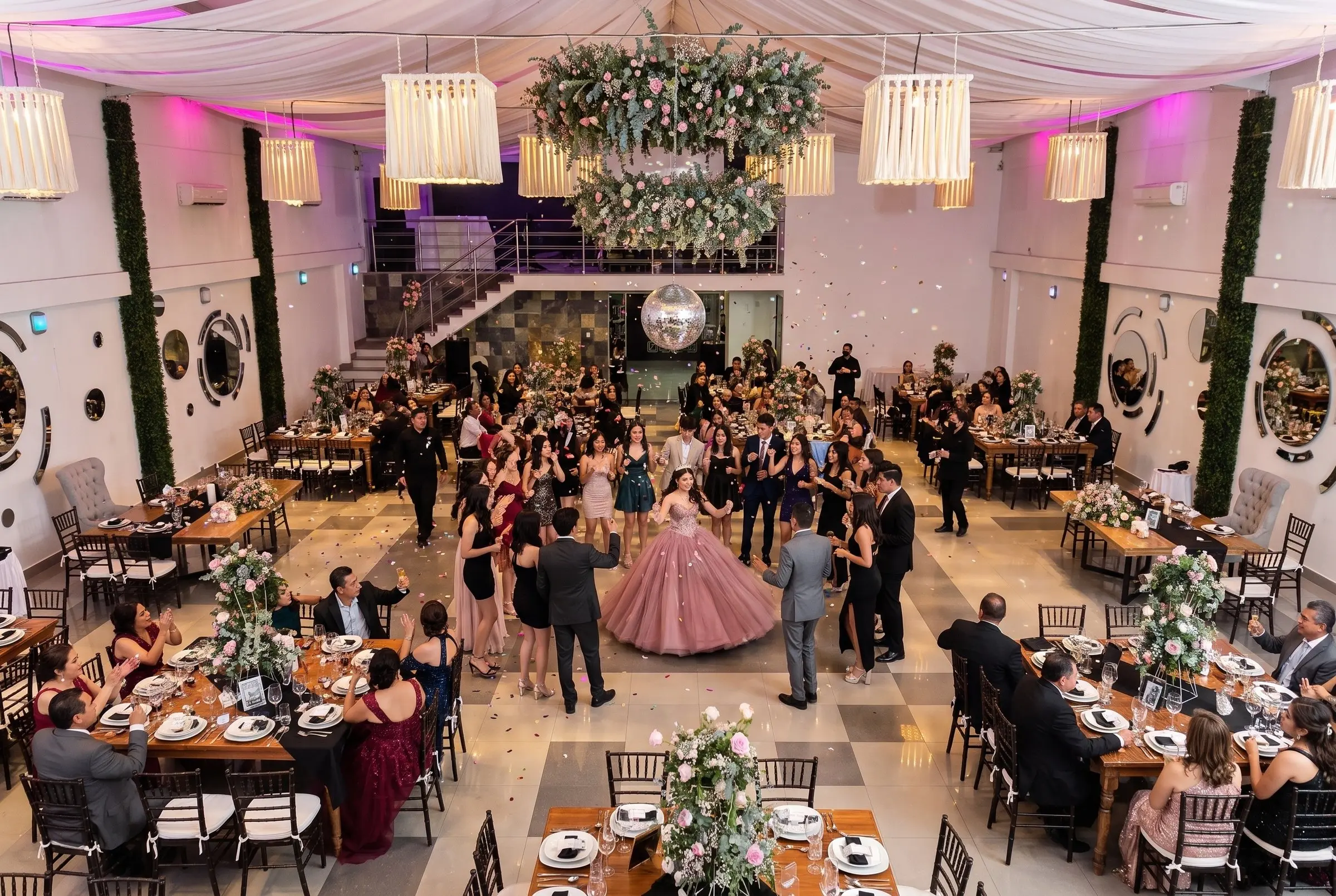 La fiesta de XV años vista desde el mezzanine: la quinceañera al centro de la pista, rodeada de sus invitados