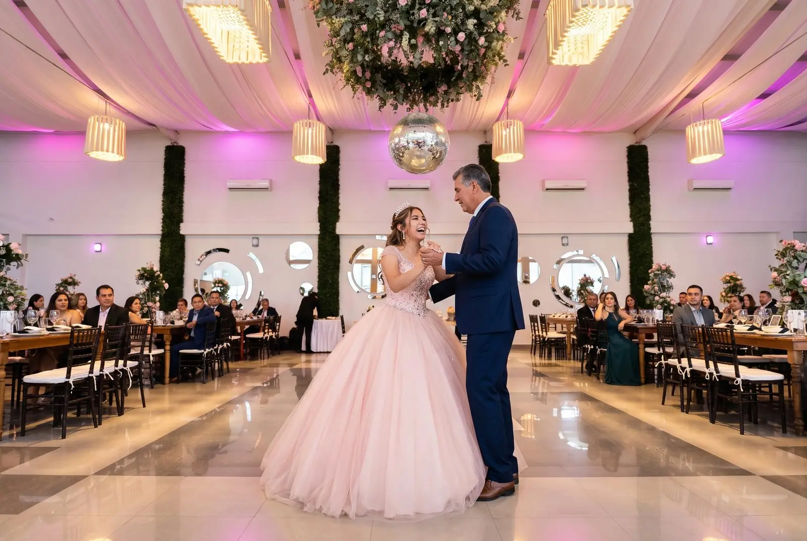 Una quinceañera baila el vals con su papá en la pista del salón