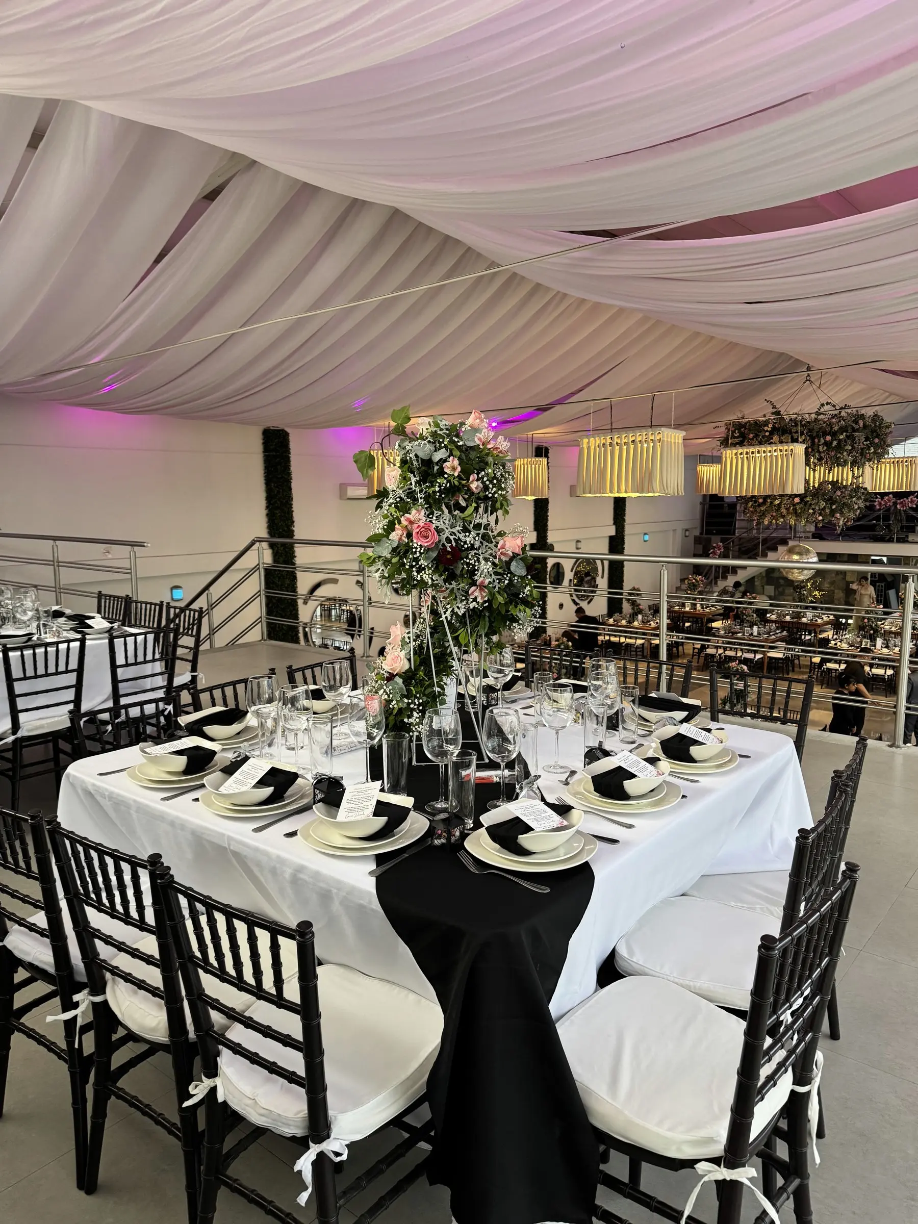 Mesa en blanco y negro sobre el mezzanine, con el salón abajo