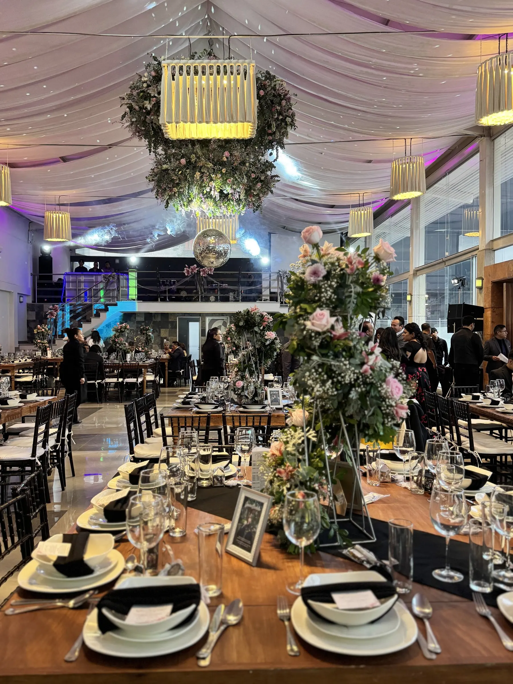 Mesa con flores y los invitados al fondo