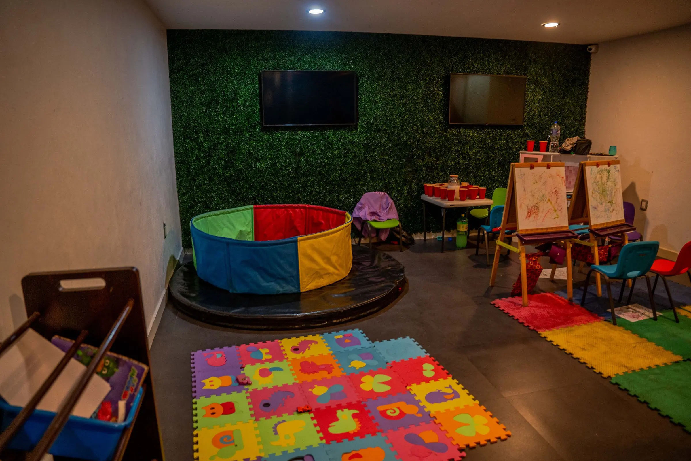 El cuarto de los niños, con alberca de pelotas, mesas a su tamaño y pantalla