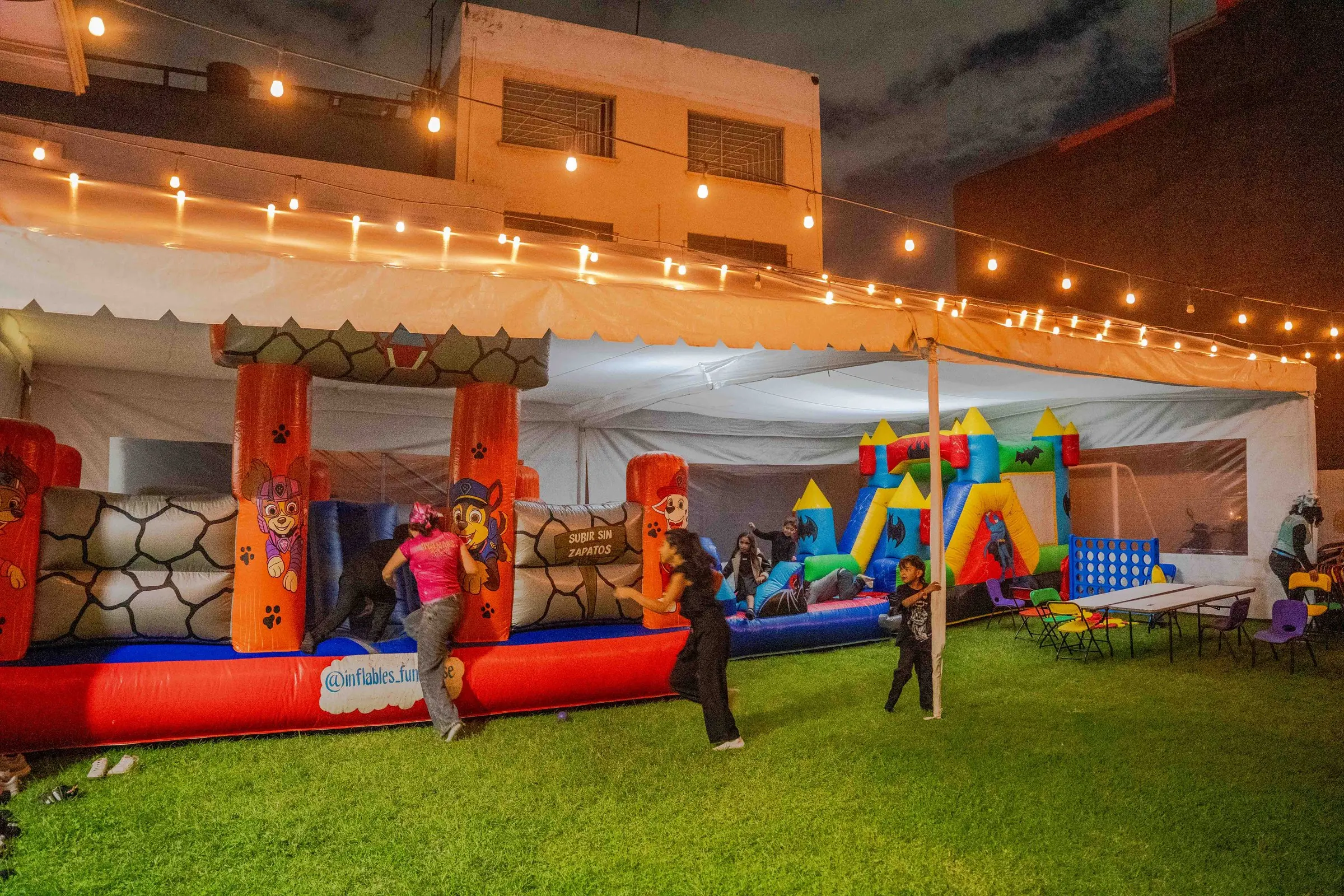 El jardín con juegos inflables bajo una carpa con luces
