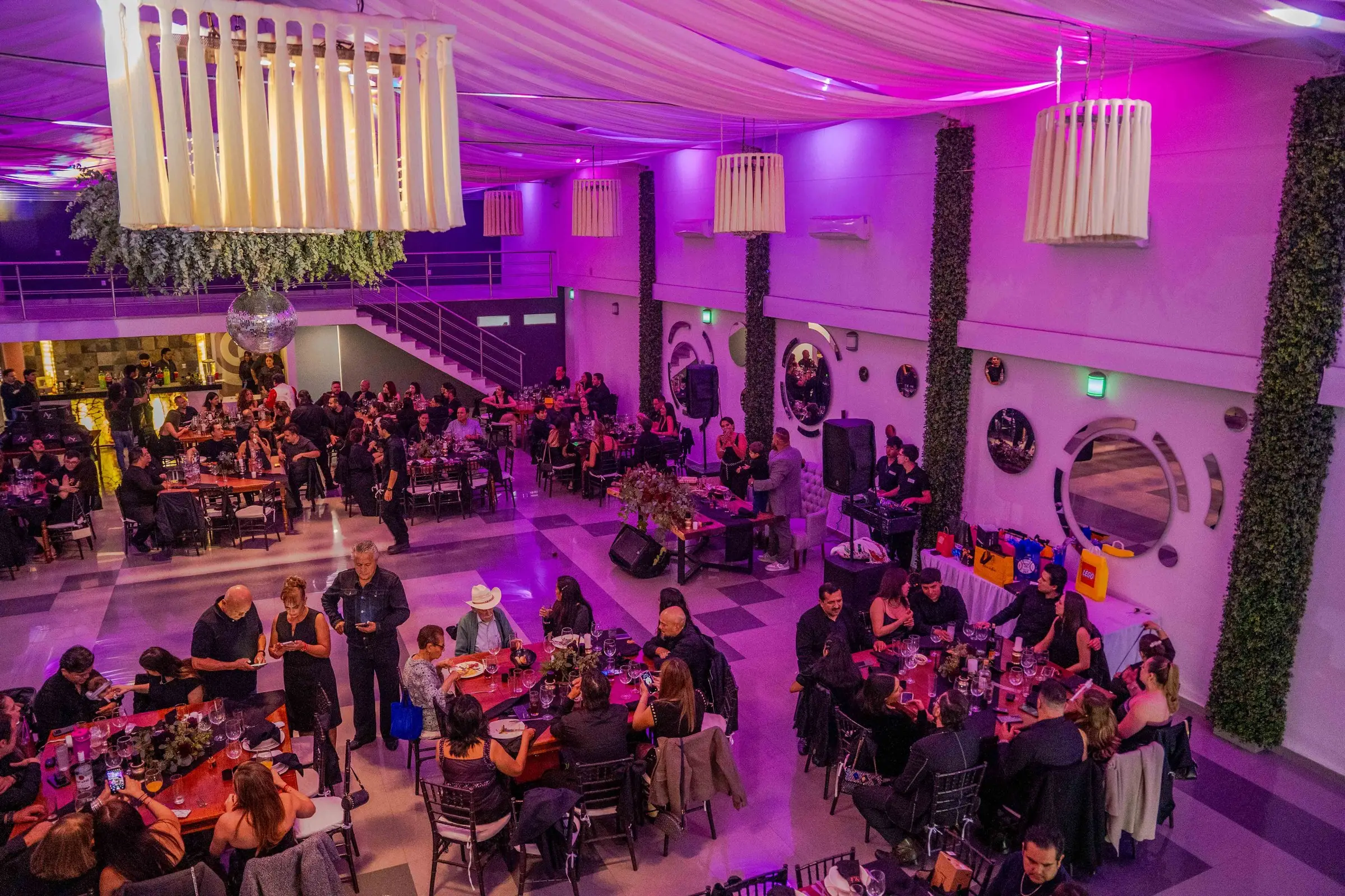 El salón en plena fiesta visto desde arriba, con las lámparas de listones encendidas