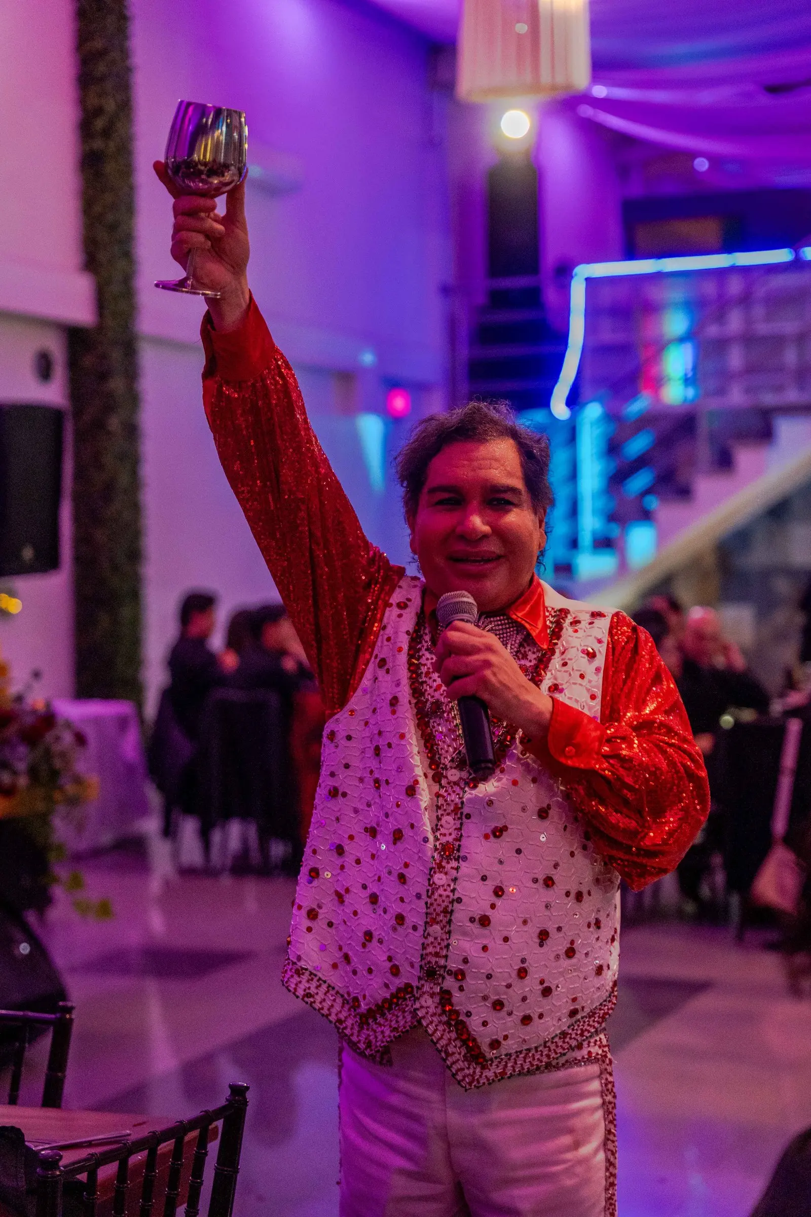 El cantante levanta su copa para brindar con el salón